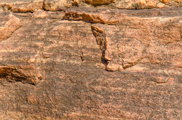 Red sandstone rock, natural tones, create mesmerizing texture and patterns, creating a natural earthy backdrop. 