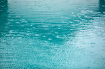 The water is blue and has raindrops on it