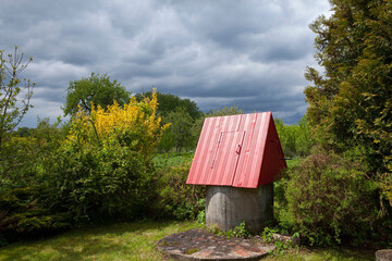 A traditional Lithuanian rural well, drawing water from underground springs. Concrete rings are sunk into the earth, where a spring fills the well with clean, fresh water.