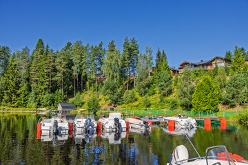 Jetty with motorboats in a forest lake a beautiful sunny day