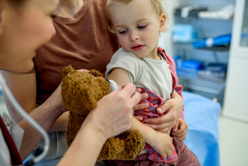 Doctor placing cotton and medical tape on the injection spot.