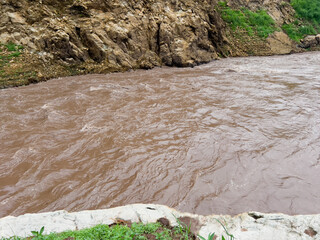 After heavy rain, the flood water from the highlands flows into the river. The water is muddy and has lots of wood chips and other things.