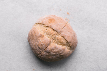 Overhead view of homemade artisan bread on a white countertop, top view of baked sourdough artisan bread on a white background