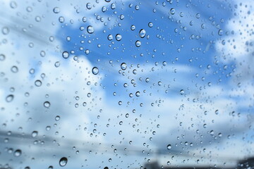 water drop on mirror with blue sky and white cloud background