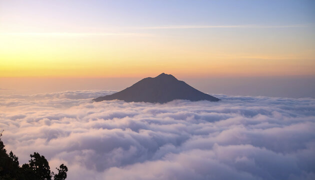 Majestic mountain peak above cloudline with warm early light at sunrise