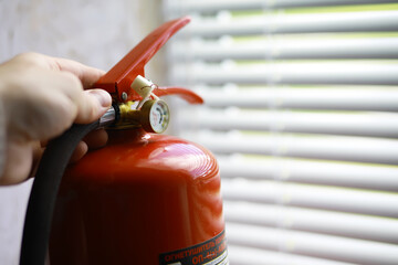 hand presses the trigger fire extinguisher available in fire emergencies conflagration damage...