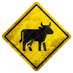 Cattle crossing warning sign with black cow silhouette and rusty texture on white background.