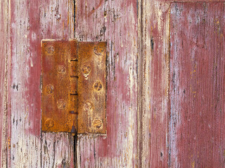 Close up of an old door with peeling paint, showing the wood grain texture