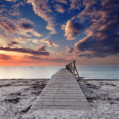 amazing sky over wooden weathered pier at the Baltic Sea beach
