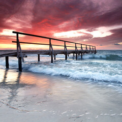 Weathered wooden pier at the baltic sea - awesome sunset over the Baltic Sea beach