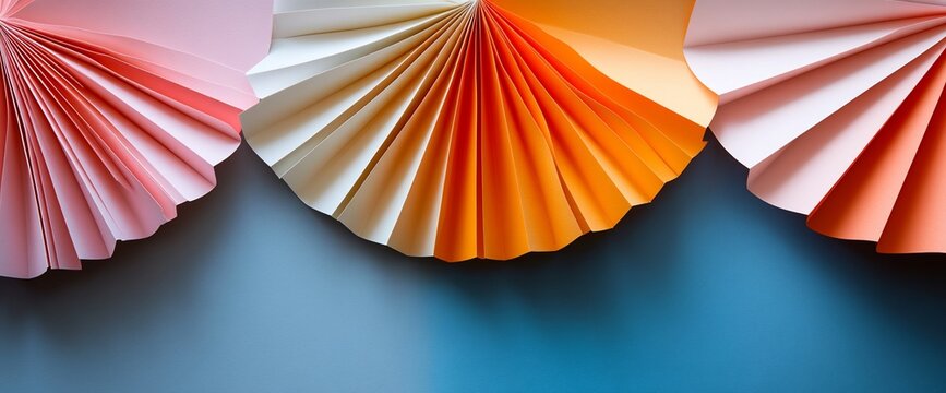 Pastel paper fans creating a festive colorful border against a blue background - Powered by Adobe