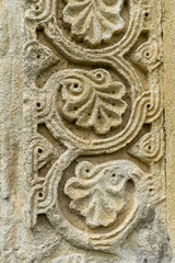 Antique bas-relief on sandstone in the form of a leaf and stem of a grapevine. Detail of the architecture of the church