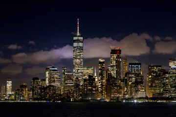 A vibrant sunset panorama of Manhattan downtown skyline, viewed from the river