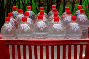 Plastic bottles filled with water in a box with red caps.