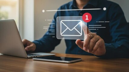 A person interacts with a digital email icon over a laptop and phone on a wooden desk surface - Powered by Adobe
