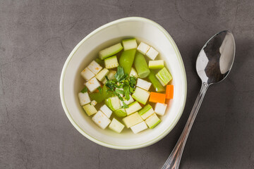 Italian minestrone soup with diced vegetables in a clear broth