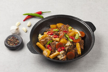  Jjimdak is a dish made by simmering chicken pieces with carrots, potatoes, garlic, peppers, green onions, onions, and glass noodles, and seasoning it with soy sauce or red pepper paste.