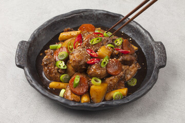  Jjimdak is a dish made by simmering chicken pieces with carrots, potatoes, garlic, peppers, green...