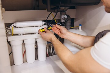 Plumber Installing Water Filter System Under Kitchen Sink