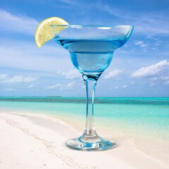 a glass of juice on a beach