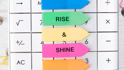 Growth Success Achievement Progress Concept. Words RISE AND SHINE motivating messages are placed on the calculator on bright stickers