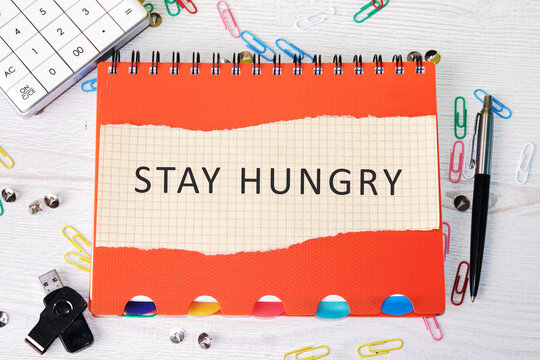 Concept Phase STAY HUNGRY written on paper on a colorful notebook - Powered by Adobe