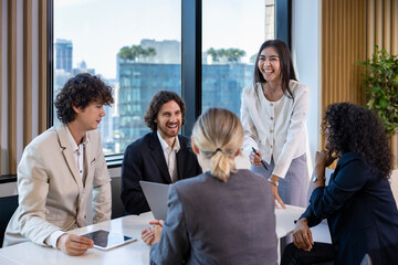 Asian woman sale manager is showing annual report to her colleague in executive meeting for next year plan with market share increase for global business and investment