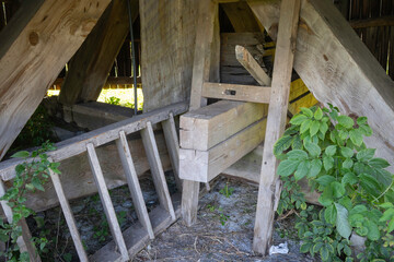 A wooden structure with a ladder and a pile of wood