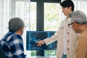 senior programmer bootcamlp,Asian young instructor guides senior learners through a programming on...