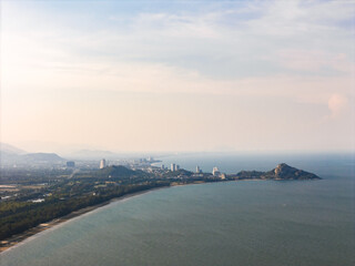 Aerial view of Suan Son Beach and Hua Hin coast with Khao Takiab mountain and city skyline in distance