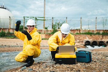 Factory Worker in Hazmat Suit Collecting Oil and Water Samples from Industrial Beach for Toxic Pollution Survey
