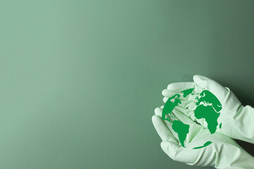Hand holding Earth globe icon on green background.,Concept for environmental protection, sustainability, conservation, Earth Day,global responsibility, climate action, eco-friendly practices.