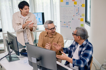 Senior developer team celebrates success in software collaboration and coding at a modern computer workstation
