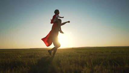 Father son play superheroes in park. Dad carries child on shoulders at sunset both wearing capes. Superhero adventure between father child in park. Family bond as father son embrace superhero fantasy. - Powered by Adobe