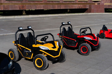 Colorful go-karts parked under sunlight in an outdoor area with smooth pavement