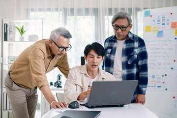 Group of asian senior in a collaborative software development analyzing  flowcharts  during a bootcamp training