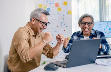 Senior developer team celebrates success in software collaboration and coding at a modern computer workstation