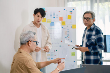 senior programmer bootcamlp,Asian young instructor guides senior learners through a programming on whiteboard, highlighting algorithm thinking and simple code exercises