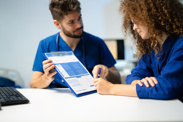 Doctor and young female patient reviewing medical form together. Concept of healthcare consultation