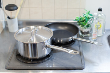 ガスコンロに置かれたフライパンと手鍋