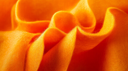 Vibrant orange fabric draping elegantly with soft texture and subtle folds captured in close-up view