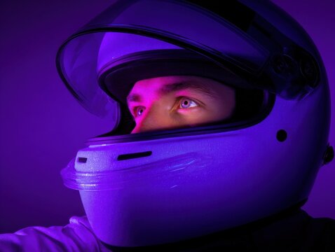 A man wearing a helmet with a purple background