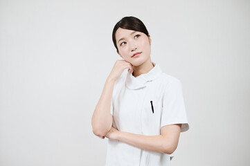 疑問を感じるポーズをする白衣の女性