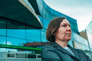 Headshot portrait of businesswoman entrepreneur on downtown city street in front of corporate office building