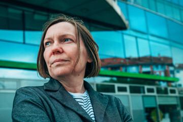 Headshot portrait of businesswoman entrepreneur on downtown city street in front of corporate office building