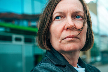Headshot portrait of businesswoman entrepreneur on downtown city street in front of corporate office building