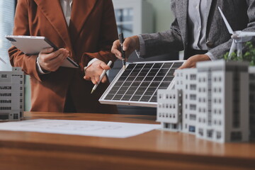 Discussion among businesspeople on the latest developments in solar cell panel technology and Solar Energy Environment city Concept.