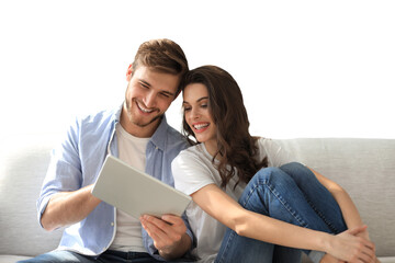 Young couple watching media content online in a tablet sitting on a sofa on a transparent background