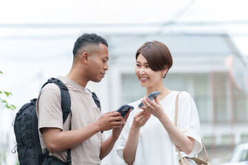 スマホ翻訳アプリで外国人に道案内する女性