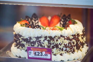 Victoria sponge cake beautifully decorated with fresh cream on display at a bakery shop in Turnpike Lane, Haringey, London